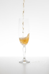 Champagne falling in glass on white background