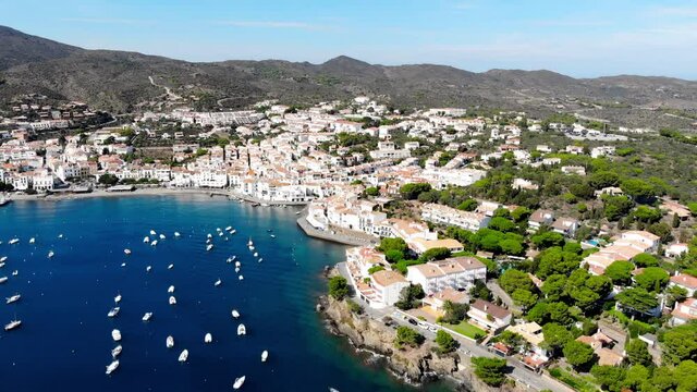 Drone shot of the coastal city of Cadaques. Small village on the Costa Brava. View from the drone of the beach and the bay in Spain. Boats in a rocky bay in Cadaques. Churches in Cadaques. 
