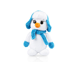 Happy snowman isolated on white background with reflection. Soft knitted toy snowman in a blue hat, scarf, mittens, front view, close-up. Christmas gift, decoration.