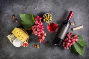 Composition of grape, cheese and wine on dark stone background. Top view