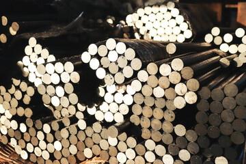 Round steel rods sawn into identical blanks for further processing on machine tools. Close-up with selective focus. 