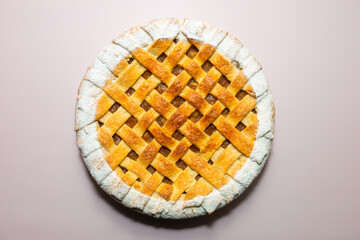 Tradition american Christmas apple pie with sugar crust top view on violet pink background