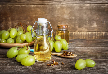 Grape seed and grapes on wooden background. Grape oil concept
