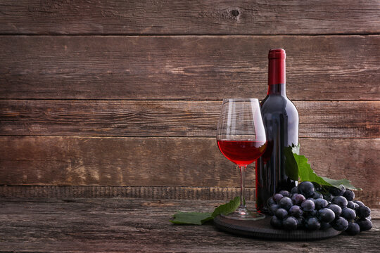 Grape and red wine on wooden background. Copy space