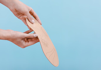 Orthopedic insole isolated on a blue background. Medical insoles. Treatment and prevention of flat feet and foot diseases. Foot care, feet comfort. Wear comfortable shoes. Flat Feet Correction.