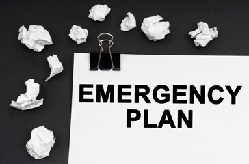 On a black background, there are crumpled pieces of paper and paper with the inscription - Emergency Plan