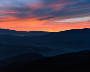 Amazing landscape in the mountains. View of mountains silhouettes and colorful sky at distance in  twilight.