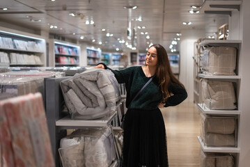 Female customer choosing duvet in shop