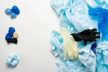 Fototapeta premium Waste of used personal protective equipment PPE, gloves, disposable masks, shoe covers of medical workers. Garbage contamination after the COVID-19 pandemic