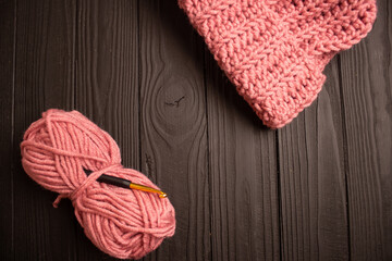 pink hat and crochet yarn on dark background