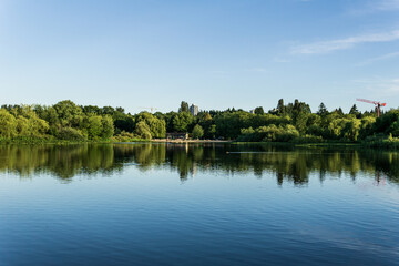 Crystal and turquoise water of the Trout Lake in Vancouver and green trees on the shore