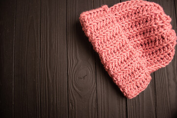 pink knitted hat for winter on a dark background
