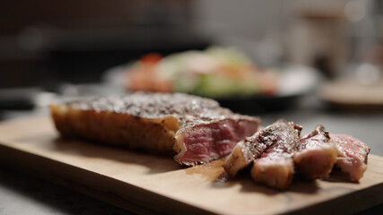 sliced new york steak on olive wood board