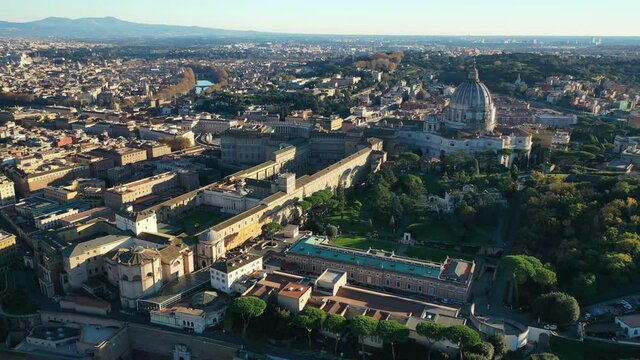 Aerial drone video of iconic masterpiece world famous Saint Peter Basilica and Sistine chapel in city of Vatican the biggest church in the world, Metropolitan city of Rome, Italy