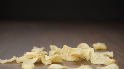 potato chips falling on wood backgorund