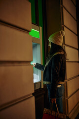 Woman using ATM machine outdoors