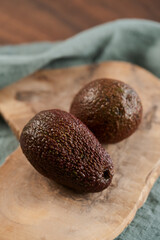 Two avocados on olive wood board