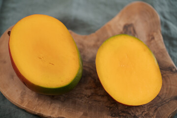 Sliced ripe red mango on olive wood board
