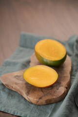 Sliced ripe red mango on olive wood board