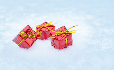 Red gifts are lying on real snow