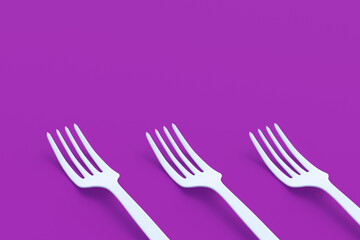 Row of forks on violet background. Copy space. 3d render