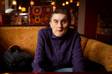 A disabled man suffering from cerebral palsy in the cafe.