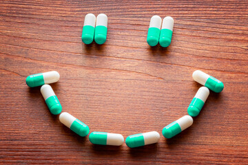 Drug benefits and side effects concept. Close up on a series of pills forming a smile and a sad face. - obrazy, fototapety, plakaty