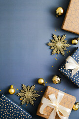 Christmas vertical blue background, xmas poster, social media stories banner design. Flat lay Christmas gift boxes and golden decorations on blue background. Top view, copy space.