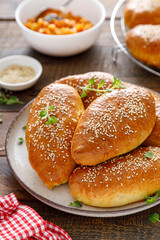 Homemade baked pies or patties stuffed with cabbage on wooden background