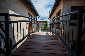 Wooden Bridge over a pub entrance with black metal railings with a beautiful blue cloud cover