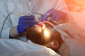 Dentist make ultrasonic teeth cleaning close-up. Removal of tartar and plaque. prevention of dental...