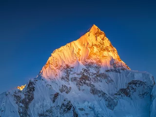 Foto op Plexiglas Mount Everest uitzicht op de gouden bergpiek in zonlicht onder de blauwe lucht met kopieerruimte