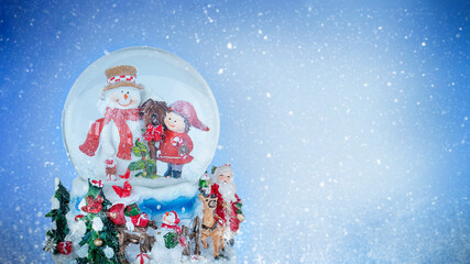 Snow globe with snowman and winter scene on blue snowy background