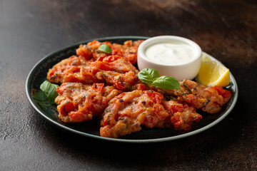 Greek tomato fritters, tomatokeftedes served with yogurt on plate.