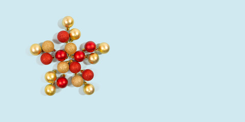 Christmas theme composition. New Year minimal concept. Red and gold Christmas baubles decoration forming a star shape with copy space. Top view, Flat lay, Space for text.