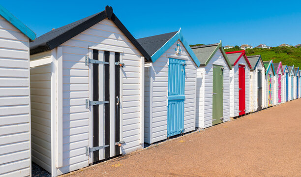 Colorful small beach houses. Multicolored beach sheds. Variety of painted beach shacks. Beach hut.