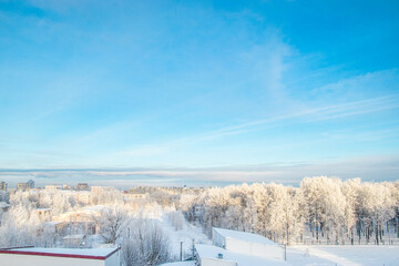 City view in winter. Houses and trees in snow. Beginning of winter season.