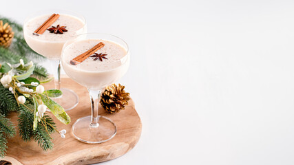 Eggnog on wooden tray, Christmas cocktail in coupe glass, top view - obrazy, fototapety, plakaty