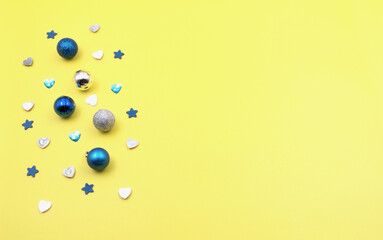 Silver and blue jewelry on a yellow background. Can be used as a holiday postcard with a message.