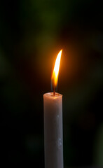 Candle light with dark bokeh background, in shallow focus