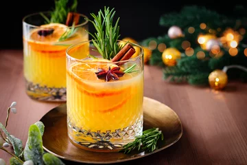 Fotobehang Winter warming bourbon old fashioned cocktail with oranges, cinnamon and rosemary © Maria Shchipakina