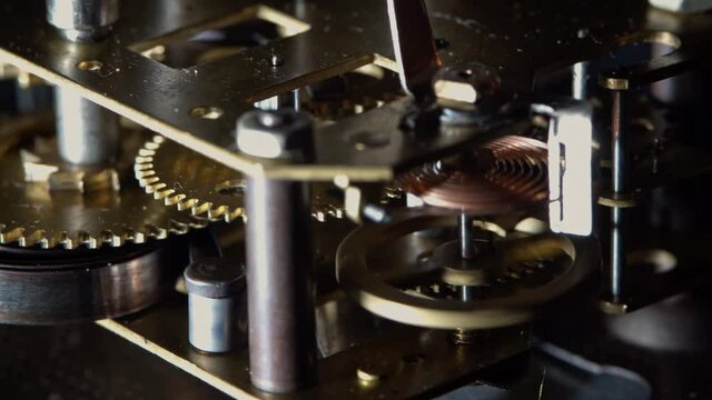 Macro video of the primitive clockwork mechanism of an old desktop alarm clock