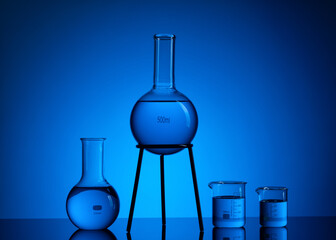 Research lab assorted glassware equipment. Blue background.