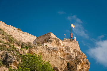 Castle of Santa Barbara with Spanish flag at top, Alicante, Spain, close up view at landmark, high resolution photo