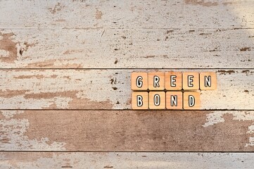 The letters arranged in the word Green Bond. It's on a wood board.