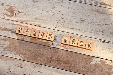 The letters arranged in the word Green Bond. It's on a wood board.
