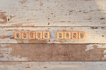 The letters arranged in the word Green Bond. It's on a wood board.