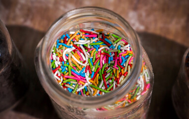 Top view of a glass jar with colorful chocolate chips.