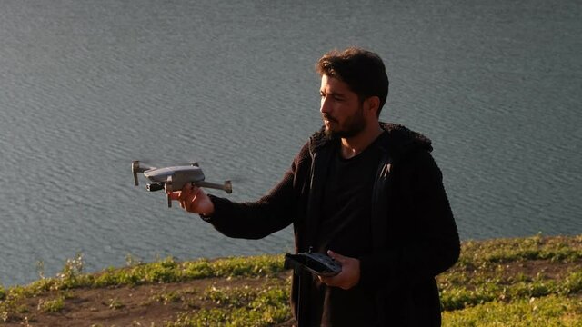 drone operator, drone operator airing drone with hand in close-up