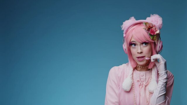 Glamorous funny fancy girl with pink hair and makeup plays like a call center operator comically talking to user or stranger and say hello. Glamour comic phone service support parody conecpt